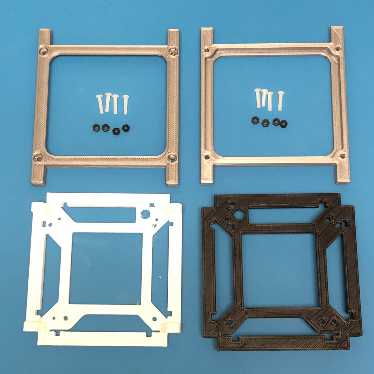 Figure 2 — The 3D-printed 1U frame components — two printed end-rail sets (top) with their mounting screws and nuts, and two interior board-mount plates (bottom) that the Pi/board stack bolts into before the …